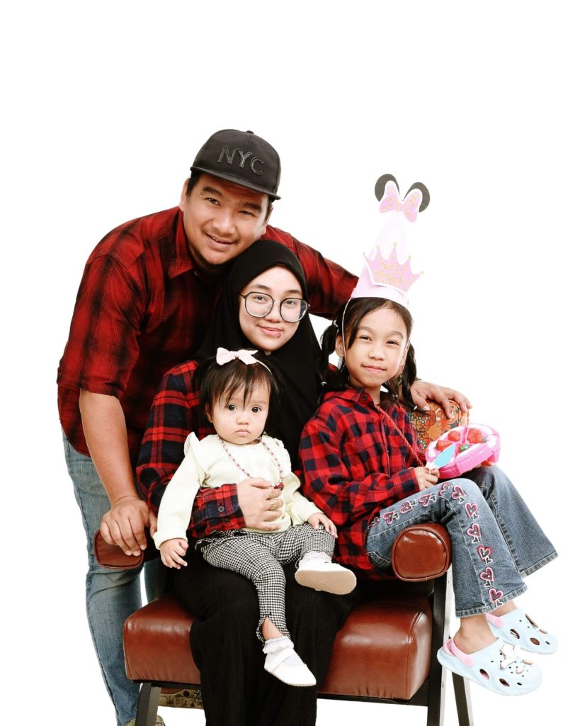 Family of four on a leather sofa, first birthday photoshoot at The Cade & Co studio Cyberjaya