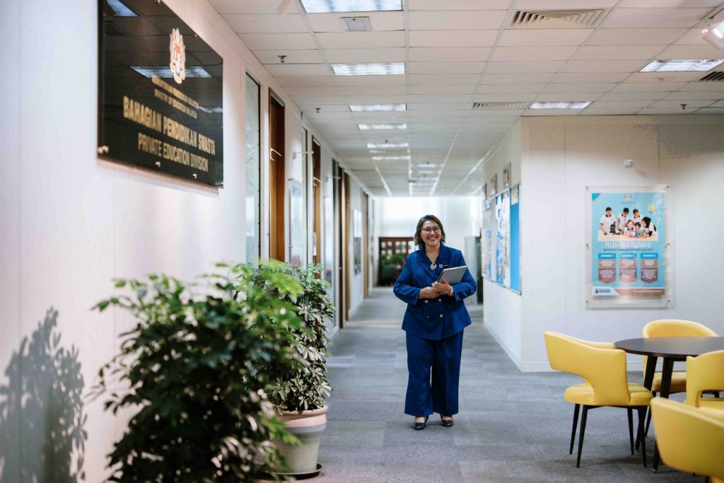 Walking portrait along the division corridor at Bahagian Pendidikan Swasta, Ministry of Education Putrajaya, corporate onsite photography by The Cade & Co