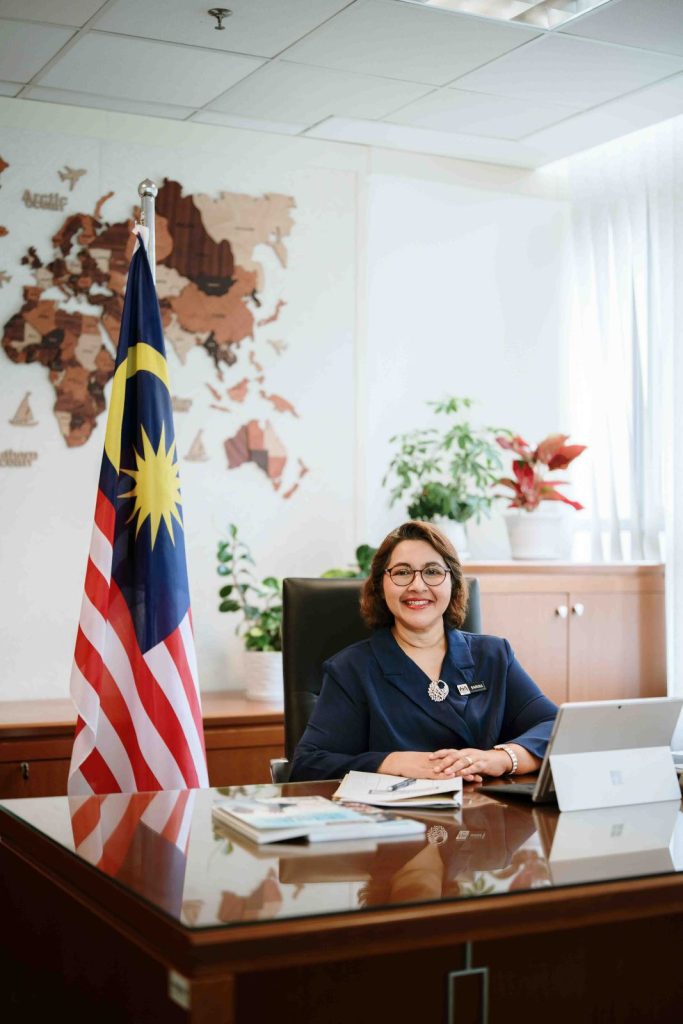 Seated portrait beside the Malaysian flag at Bahagian Pendidikan Swasta, Ministry of Education Putrajaya, corporate onsite photography by The Cade & Co