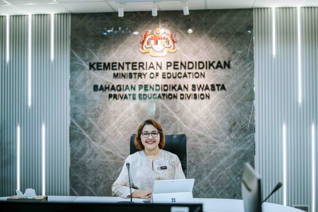 Portrait in front of the Bahagian Pendidikan Swasta signage at Bahagian Pendidikan Swasta, Ministry of Education Putrajaya, corporate onsite photography by The Cade & Co