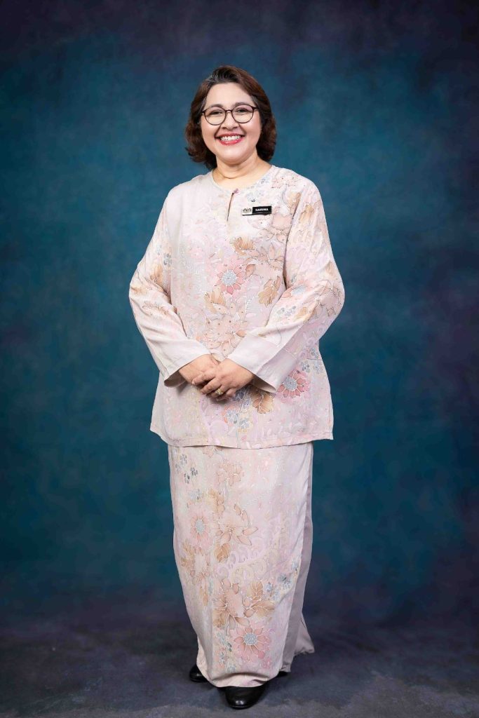 Formal portrait in baju kurung on a textured backdrop at Bahagian Pendidikan Swasta, Ministry of Education Putrajaya, corporate onsite photography by The Cade & Co